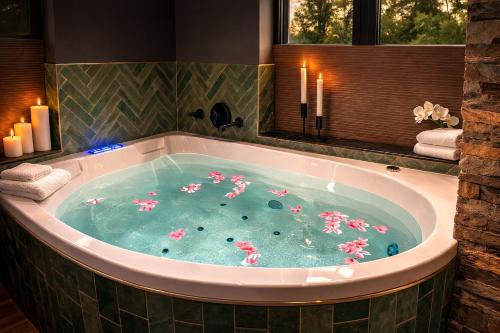 a jacuzzi tub with pink flowers in it at Wellness Tuin - Ultieme Partner Beleving - St Hubertus Suite met Indoor Jacuzzi, Openhaard, Privé Hottub en Privé Sauna in Jachthut stijl - Gratis Fles Prosecco & Leuke Partner connect box ! in Horst