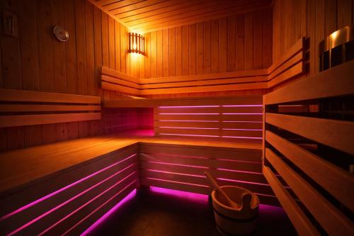 a sauna with purple lighting in a wooden room at Wellness Tuin - Ultieme Partner Beleving - St Hubertus Suite met Indoor Jacuzzi, Openhaard, Privé Hottub en Privé Sauna in Jachthut stijl - Gratis Fles Prosecco & Leuke Partner connect box ! in Horst
