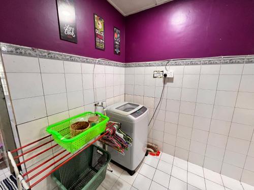a small bathroom with a toilet and purple walls at Aznah’s Stay in Kuching