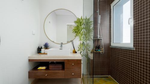 a bathroom with a sink and a mirror at DuskLine Villa by LovelyStay in Arco da Calheta