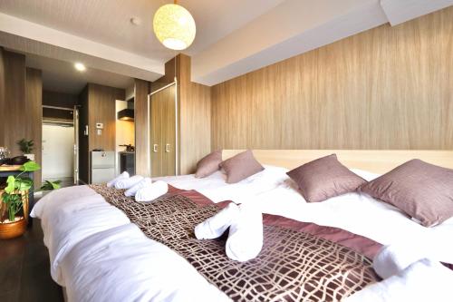 a bedroom with a large bed with white sheets and pillows at Kyo-wa Hotel Oshiage in Tokyo