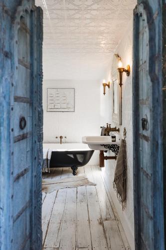 a bathroom with a tub and a sink in it at Bushy Summers - A Nurturing Bayside Shack in Strahan