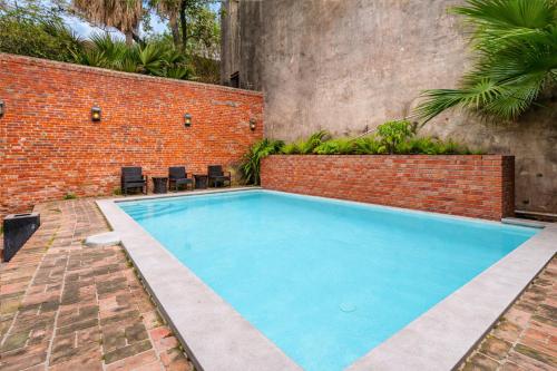 a swimming pool next to a brick wall at Roami at St. Helene in New Orleans