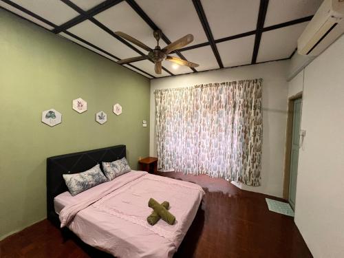 a bedroom with a bed with a teddy bear on it at Aznah’s Stay in Kuching