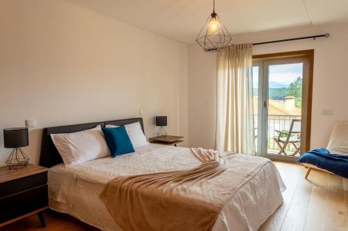 a bedroom with a large bed and a balcony at Mirador House in Vila Garcia