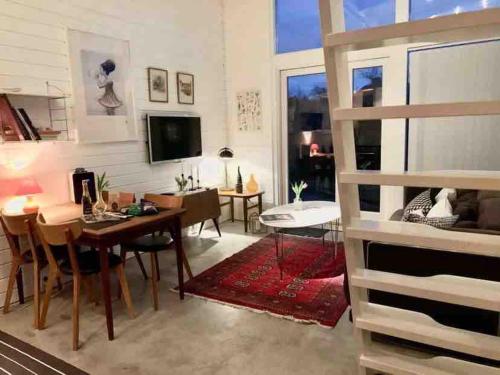 a living room with a table and a dining room at Harbor Breeze & Garden Peace in Åhus