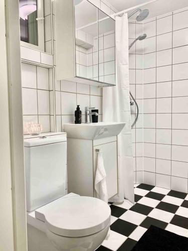 a white bathroom with a toilet and a sink at Harbor Breeze & Garden Peace in Åhus