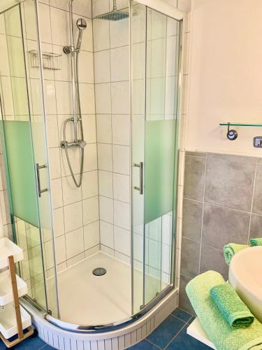 a shower with a glass door in a bathroom at Zimmer mit Bad und Balkon in Widen
