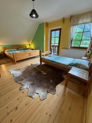 a bedroom with two beds and a rug on the floor at Domačija Plesnik in Solčava