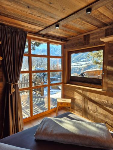 a bedroom with a large window in a room with a bed at Chalet Gletscherblick Stubai in Mieders
