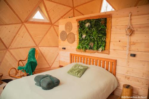 a bedroom with a bed in a wooden room at Les Dômes de Draëck in Zutkerque