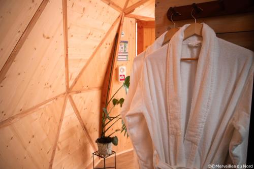 a room with a white robe hanging on a wall at Les Dômes de Draëck in Zutkerque