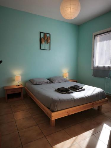 a bedroom with a bed with blue walls and two lamps at Gîte du petit chemin in Châtillon-en-Diois
