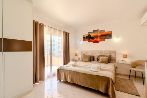 a bedroom with a large bed and a large window at Villa Orange with private pool Albufeira in Albufeira
