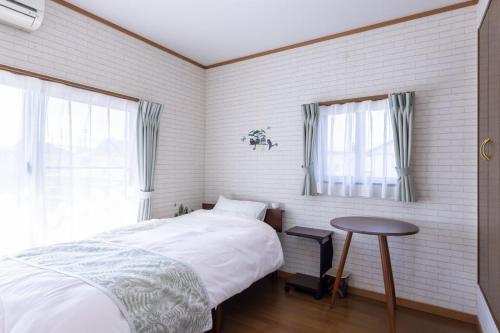 a bedroom with a bed and a table in it at Irest Village Matsumoto 2 in Matsumoto