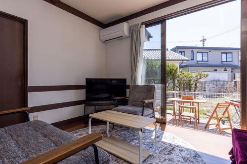 a living room with a couch a table and a television at Irest Village Matsumoto 2 in Matsumoto