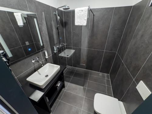 a bathroom with a sink and a shower and a toilet at RINGRAST Boxenstopp mit HERZ in Spielberg
