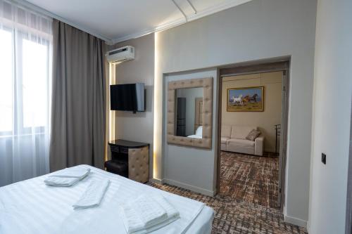 a hotel room with a bed and a mirror at DeLuxe PLAZA in Almaty