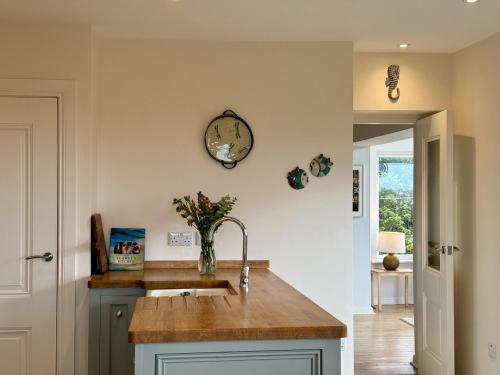 a kitchen with a sink and a clock on the wall at Cottage 498 - Cleggan in Cleggan