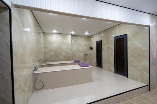 a large bathroom with a tub and a shower at DeLuxe PLAZA in Almaty