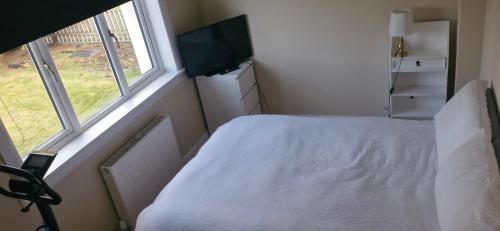 a bedroom with a white bed and a television at Double room in rosyth in Rosyth