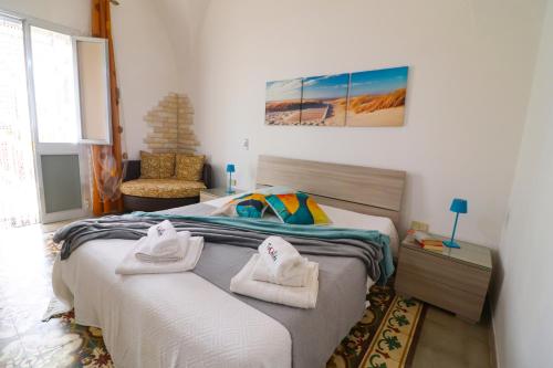 a bedroom with a bed with towels on it at Kyma's House in Otranto in Otranto