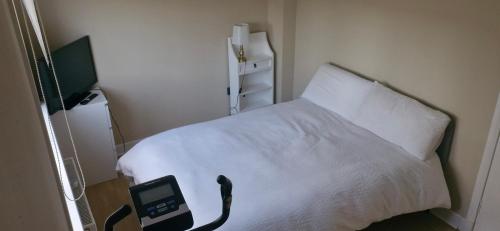 a bedroom with a white bed and a tv at Double room in rosyth in Rosyth