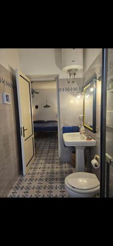 a bathroom with a white toilet and a sink at A casa di Ale in Stromboli
