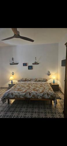 a bedroom with a bed and two lamps on the wall at A casa di Ale in Stromboli