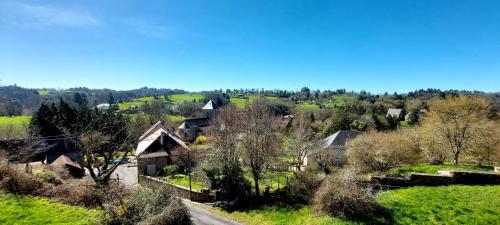 a view of a village with trees and a road at Le Verger Chambres d'hotes in Ségur-le-Château