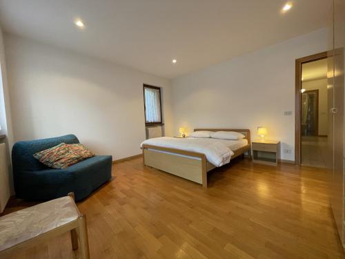 a bedroom with a bed and a chair in it at Appartamento Vadaione Est in Giustino
