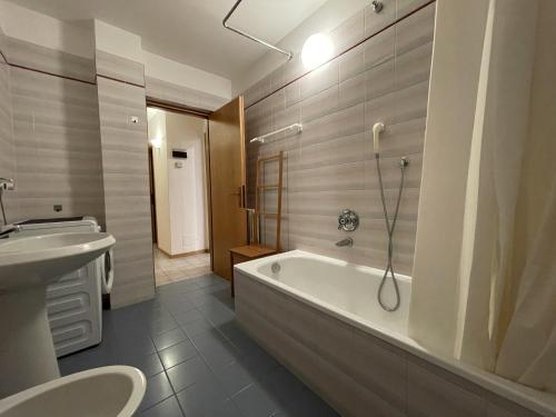 a bathroom with a tub and a sink and a toilet at Appartamento Vadaione Est in Giustino