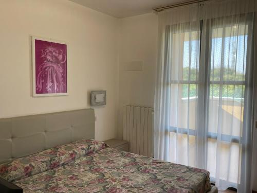 a bedroom with a bed and a window at Marina Fiorita in Grado