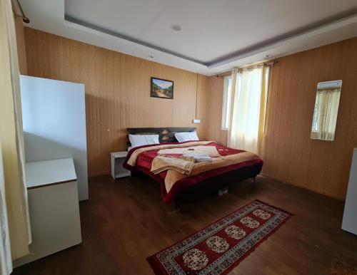 a bedroom with a bed with a red comforter at 7 Hills Resort Kanatal in Kanatal