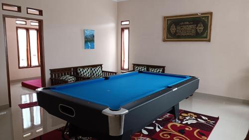 a pool table in a living room with chairs and ahibition at Villa 4 Kamar Tidur Dengan Kolam Renang Pribadi in Puncak