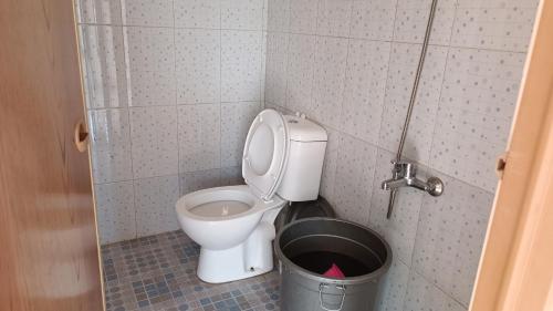 a small bathroom with a toilet and a bucket at Villa 4 Kamar Tidur Dengan Kolam Renang Pribadi in Puncak
