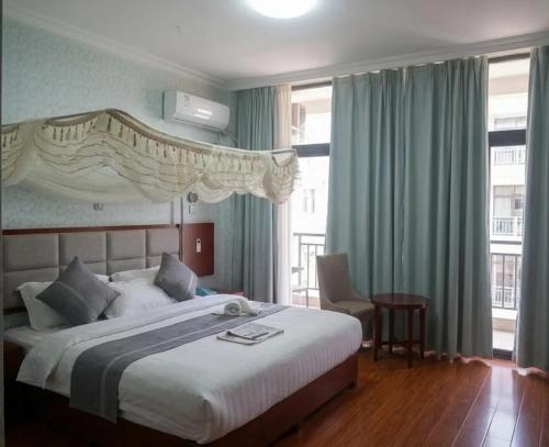 a bedroom with a large white bed with blue curtains at Fidel Hotel in Bahir Dar