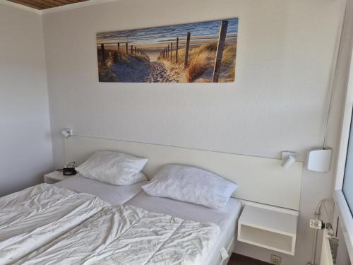 a bedroom with a bed and a picture on the wall at Feriengarten Dahme W 20 in Dahme