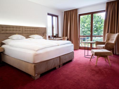 a hotel room with a large bed and a chair at Hotel Cvilín in Krnov