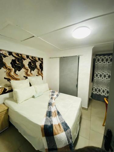 a bedroom with a bed with a tie on it at Inspan Home & Lodge in Bellville South