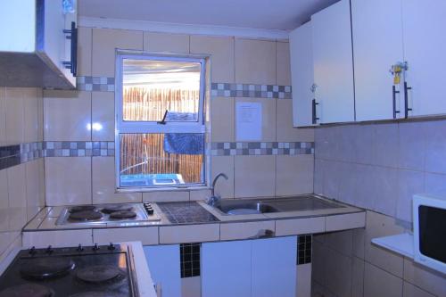 a kitchen with a sink and a window at Inspan Home & Lodge in Bellville South