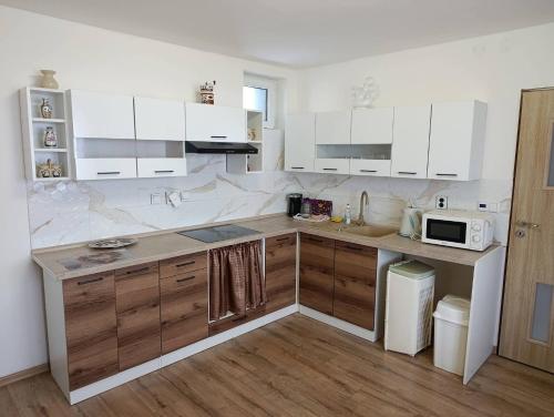 a kitchen with white cabinets and a counter with a microwave at Dům u Skašků - Žabeň in Žabeň