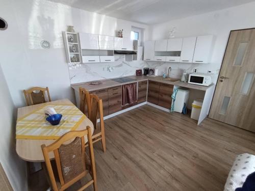 a kitchen with a table and a small table and a table and chairs at Dům u Skašků - Žabeň in Žabeň
