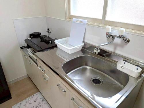 a sink in a kitchen with a counter top at LemonRooms in Aomori