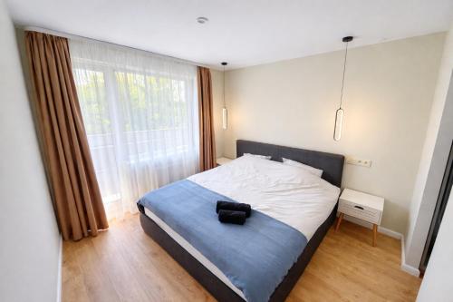 a bedroom with a bed and a large window at ZB Apartment with Free Private Parking in Rēzekne