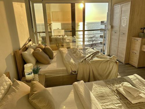 a bedroom with two beds and a view of the ocean at Apart-Hotel Saraj in Dobra Voda