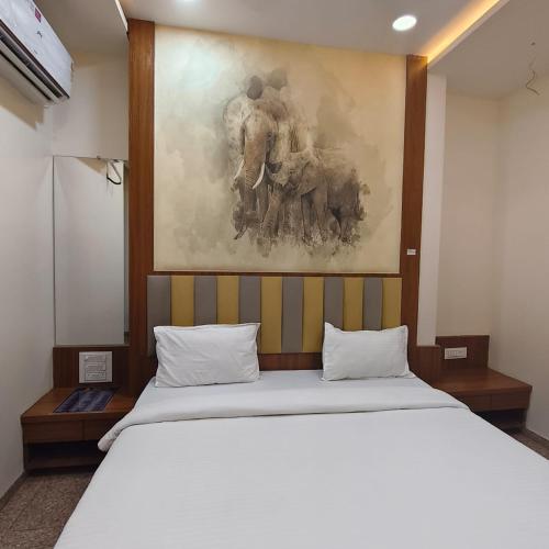 a bed in a room with a painting on the wall at Sai Srushti Residency in Kalyan