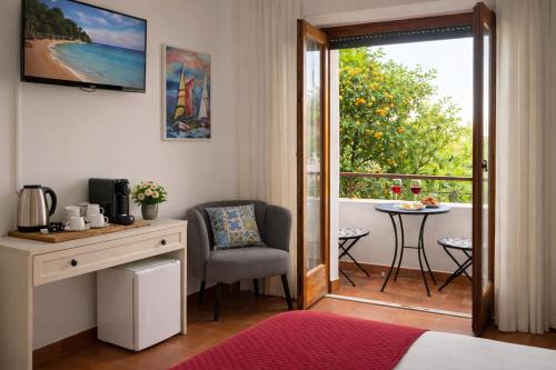 a room with a bed and a desk and a balcony at Stella Marina Sea & Sun in Cefalù