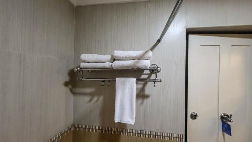a pile of towels on a towel rack in a bathroom at Hotel White City in North Paravur