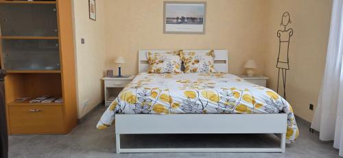 a bedroom with a bed with a yellow and white comforter at La demeure Flieg in Cernay